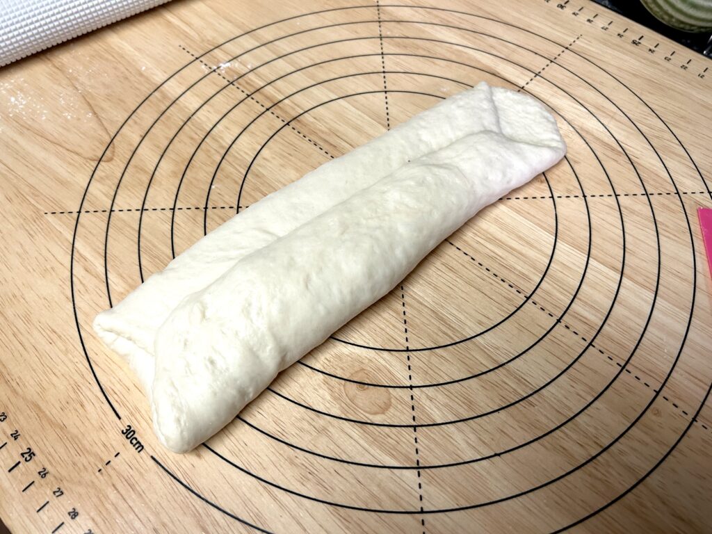 端が向かい合わせになるように折る